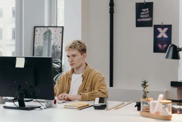 Young man concentrating on a computer screen at his modern workspace. Hospitality marketing strategy tools under review: the good, the weak and the verdict